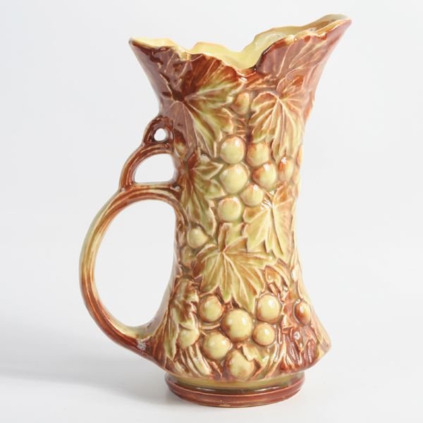 Lot of three sculptured pottery items, McCoy,(1): Lot of three sculptured pottery items, McCoy,(1) 10"t clown cookie jar, glaze crazing, (2) 9"t grape pattern ewer, good condition, (3) 7 1/2"t deer planter, good condition.