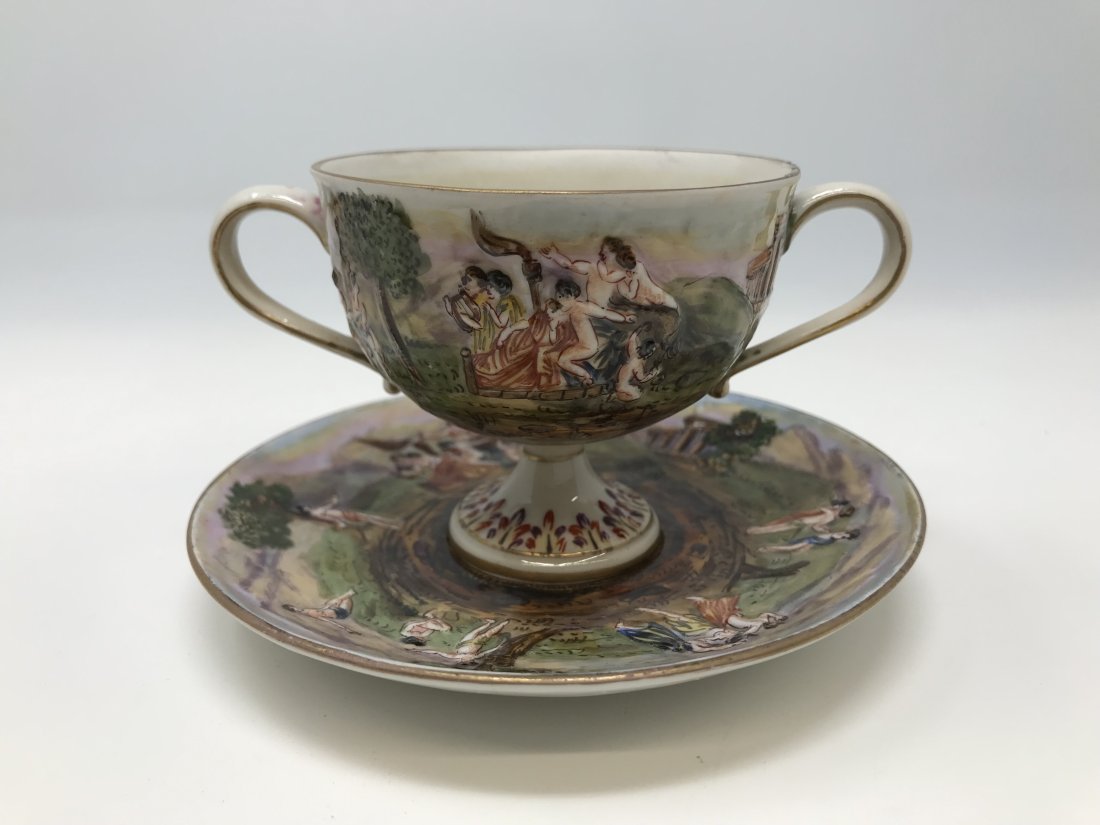 Italian Antique Capodimonte Demitasse Cup & Saucer: Italian antique capodimonte demitasse double handle cup & saucer. Decorated with scenes Bacchante, signed at the base. In good condition.