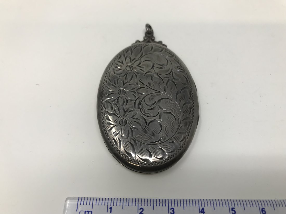Sterling Silver Locket Pendant: Sterling silver locket pendant marked on the back. Measures 6.54 cm x 4 cm wide.