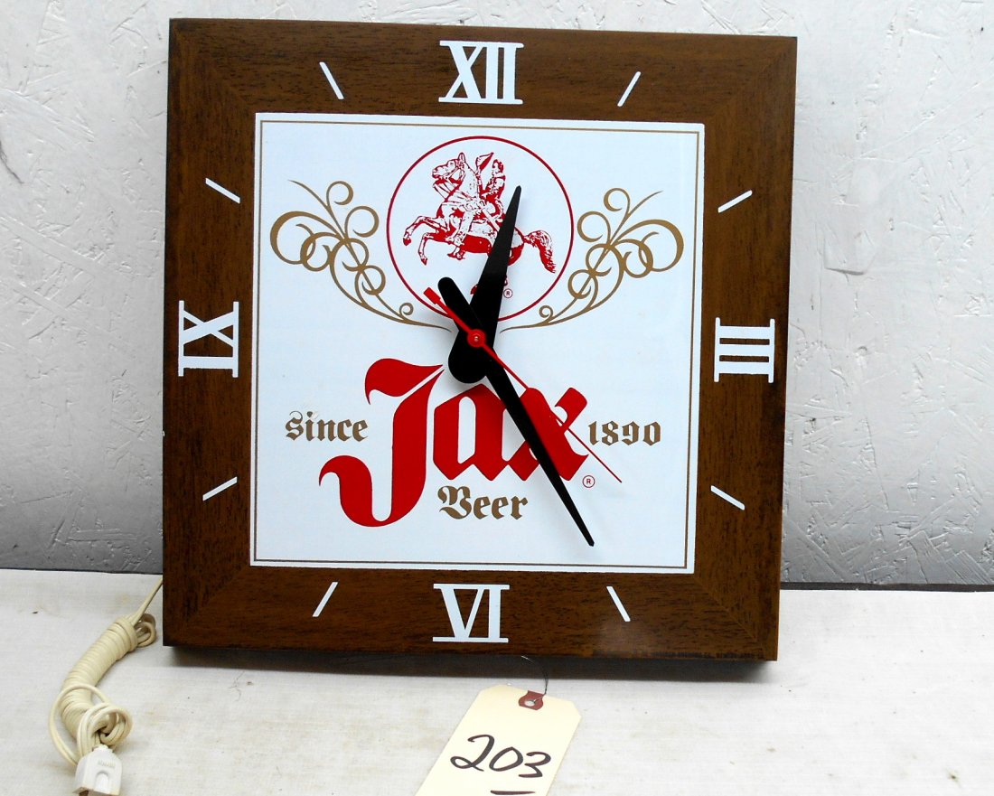 JAX BEER Clock: Vintage JAX BEER wall clock advertiement. Square, faux wood frame ,and metal clock with Jax Beer logo on face. Clock runs and lights up. 14" H x 14" W x 1.75" D. SEE VIDEO: