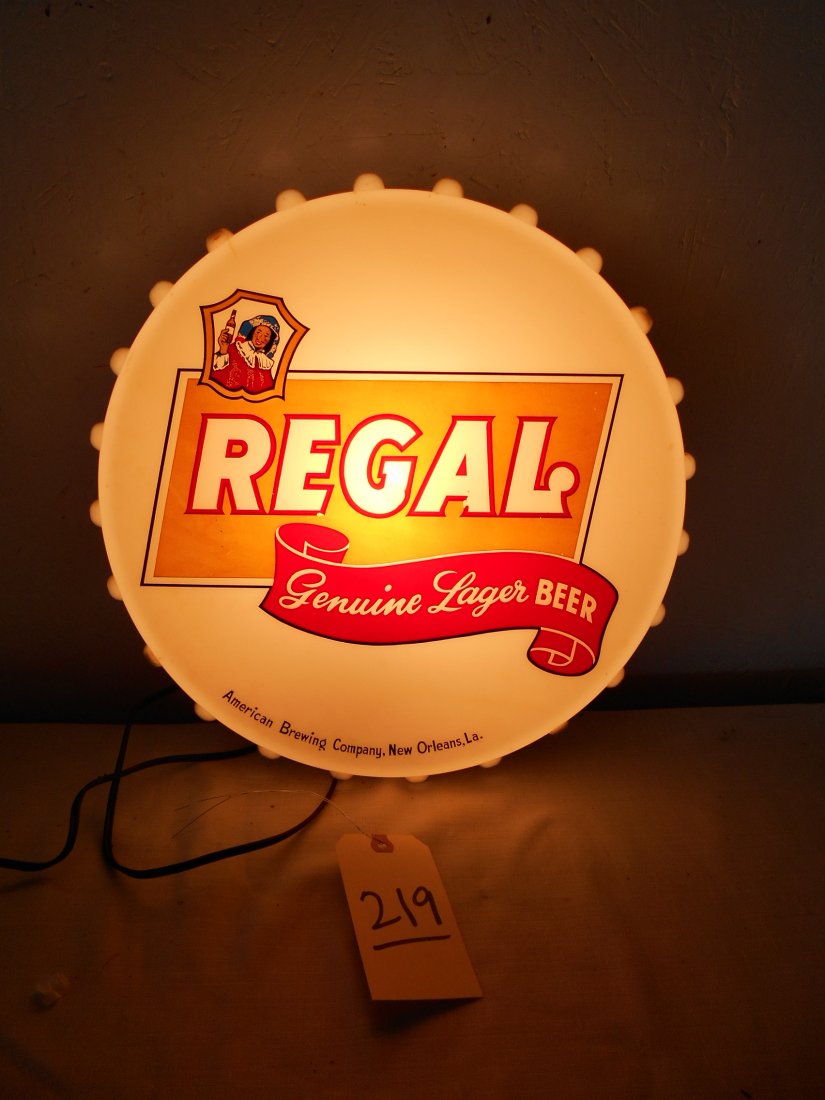 REGAL BEER Light Up Bottle Cap Sign: Vintage REGAL BEER advertisement light up bottle cap shapped plastic wall sign. Yellow and red logo on front. Made by the Ohio Advertising Company. Plastic has hairline fractures in some spots on the