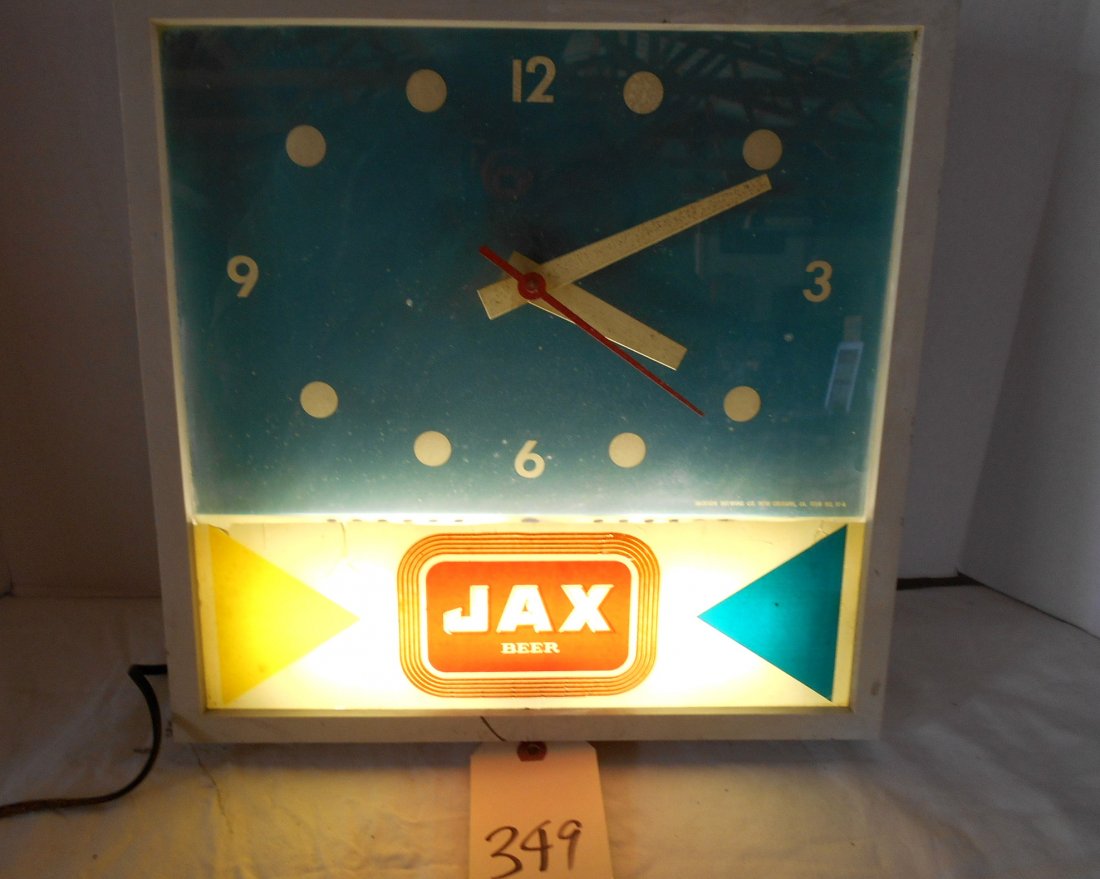 JAX BEER Clock: Vintage JAX BEER wall clock advertisement. Blue background. Metal and plastic case. Lights up and second hand on clock moves when plugged in.Plastic case is not cracked, but Jax label inside case has