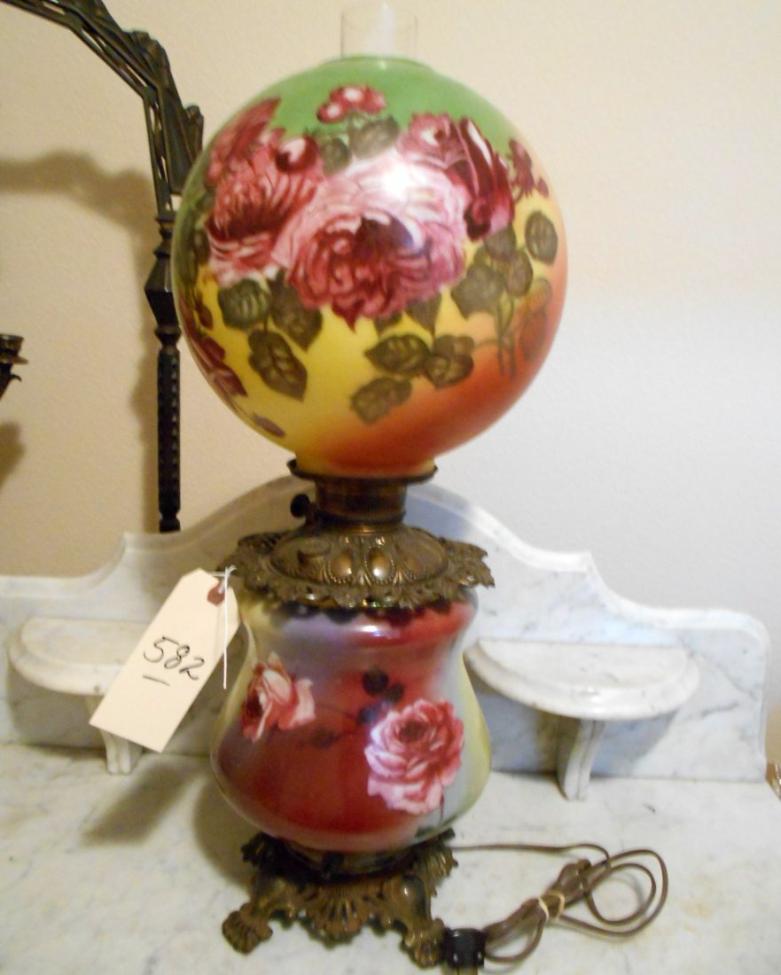 Antique Gone with the Wind Table Lamp "“ Electrified: Large antique American antebellum oil lamp which has been electrified. With original kerosene reservoir. Heavy brass base and hardware. Hand painted rose motif. Has chimney. Losses to paint very, very