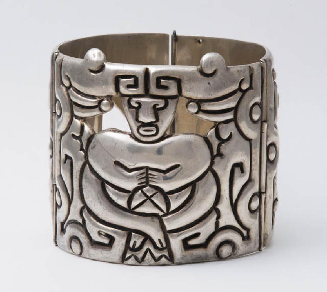 HEAVY SILVER CUFF BRACELET Marked "Taxco", and "Taller: HEAVY SILVER CUFF BRACELET Marked "Taxco", and "Taller de Los Ballesteros", deeply carved designs with a seated figure with headdress in the middle, c. 1940-1942, 4.25 ozt.