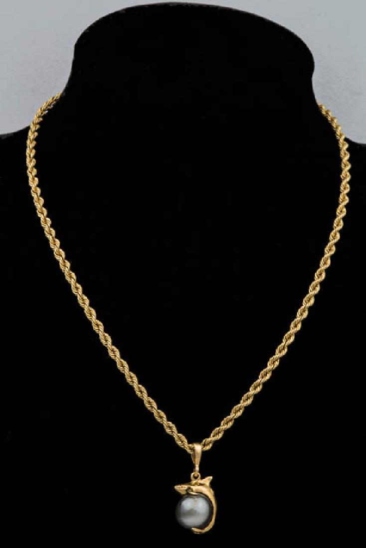 GOLD CHAIN WITH DOLPHIN 14K dolphin holding a black: GOLD CHAIN WITH DOLPHIN 14K dolphin holding a black pearl, on a 14K twist gold chain, 15" l, 12.05 G Total Wt chain, 7.75 DWT, 10.5mm pearl.