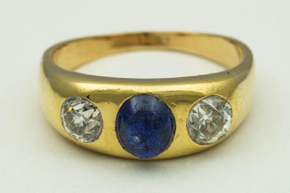 SAPPHIRE AND DIAMOND RING Gold ring with an oval: SAPPHIRE AND DIAMOND RING Gold ring with an oval sapphire cabuchon 7 x 5.96 x 3.810, set with two diamonds on either side, 1.34 CTW, 18.94mm ring size, size 9.