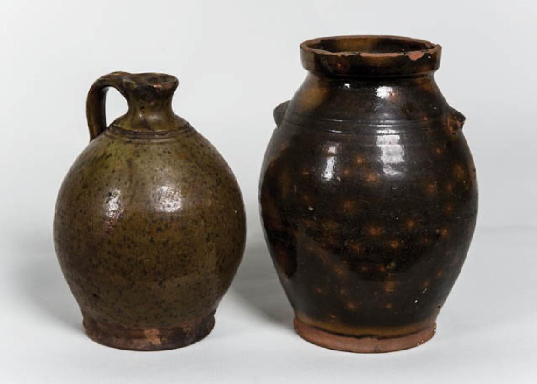 TWO EARLY REDWARE PIECES Coastal Maine (Skowhegan):: TWO EARLY REDWARE PIECES Coastal Maine (Skowhegan): Ovoid crock, orange spots on dark green glaze, some chipping around rim, incised lines at small handles, 10" h; Ovoid jug, light green/brown glaze,