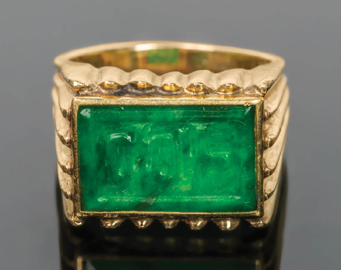 GOLD RING WITH JADE: GOLD RING WITH JADE Marked 14K gold ring, with a rectangular carved jade stone with Chinese calligraphy, size 8, 13.88 gms overall wt with stone.