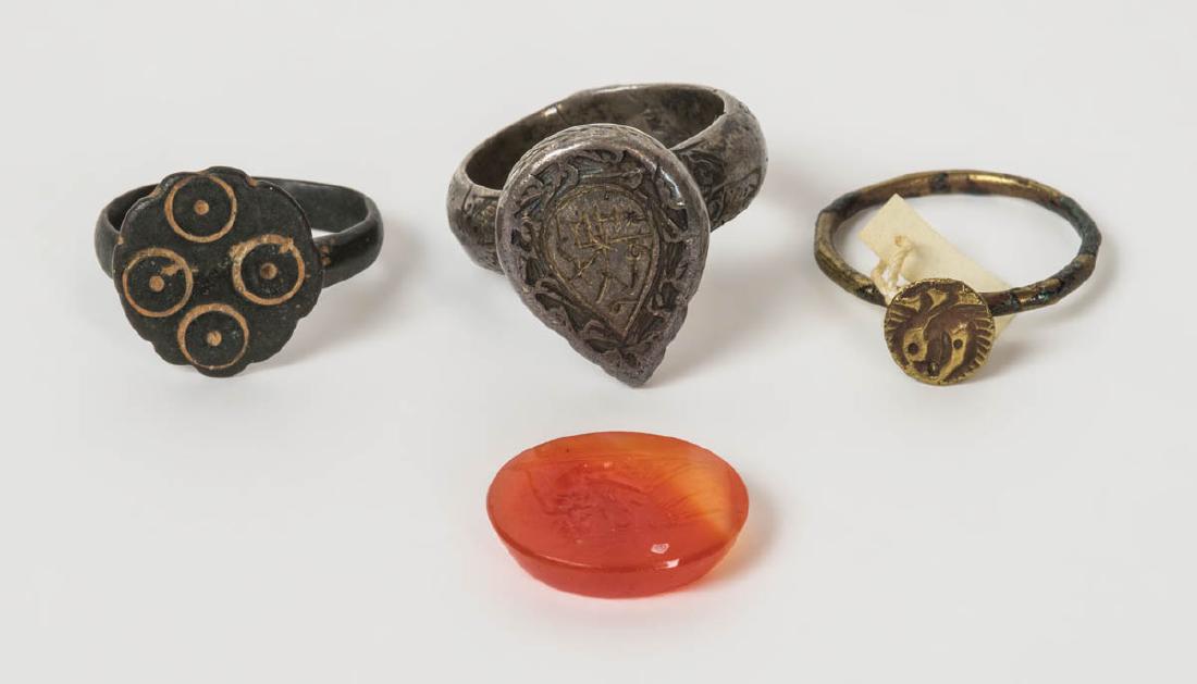 ANCIENT RINGS, AND CARNELIAN: ANCIENT RINGS, AND CARNELIAN Silver, gold, engraved as signet rings, Roman and earlier, and an intaglio (Greek) oval carnelian depicting "Leda and the Swan", (1.5 x 1.8 cm), possibly Hellenistic perio