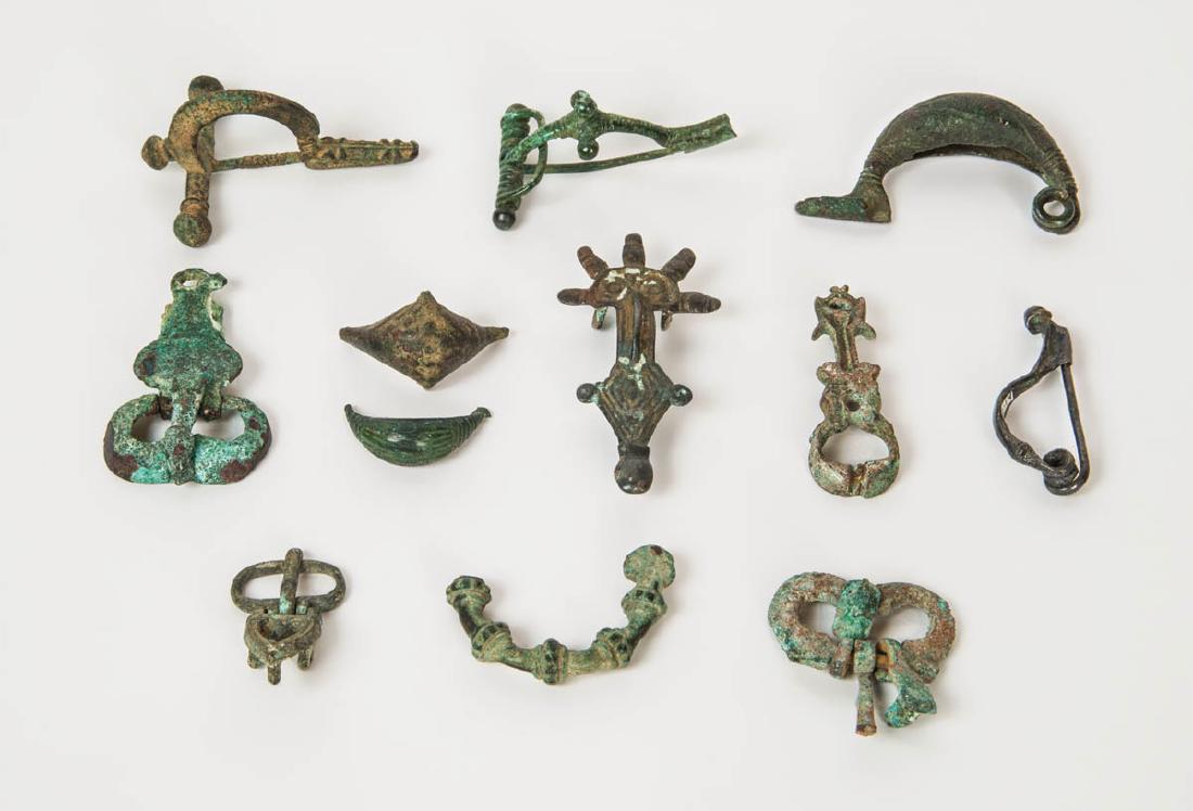 ROMAN BRONZE FIBULA: ROMAN BRONZE FIBULA Collection of Roman bronze fibula, cross-bow type, introduced into Italy by the Gallic invasion, 3rd-4th c. AD, greenish patina; three boat-shaped fibula; and Merovingian fibula an