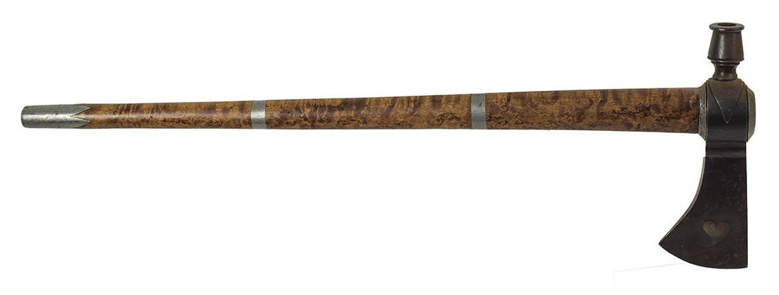TOMAHAWKPipe tomahawk with an etched heart design: TOMAHAWKPipe tomahawk with an etched heart design in the blade, a figured maple haft with a pewter eye cap, pewter bands, and a pewter pipe end knob cover, minor wear, age undetermined, 20 3/4" l.