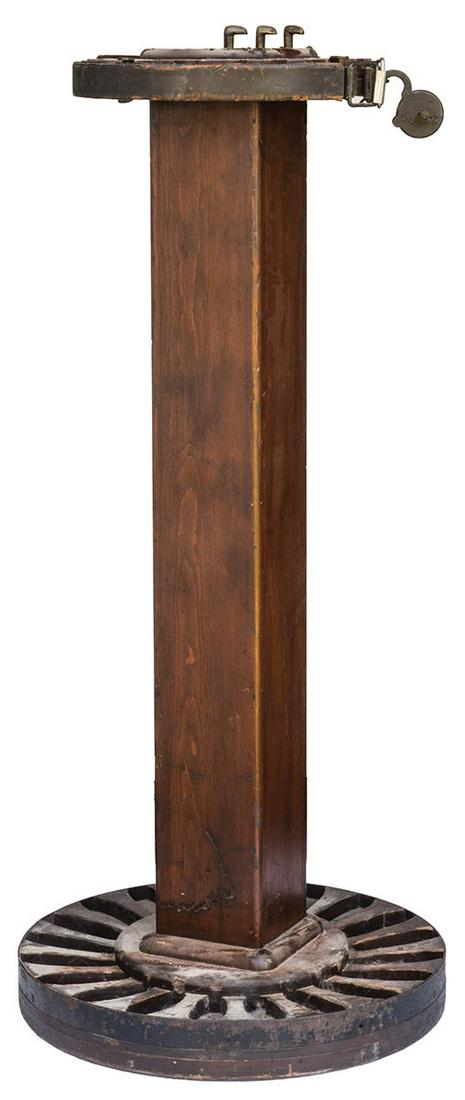 ROUND 20-GUN STANDWooden pedestal stand (51" h), with a: ROUND 20-GUN STANDWooden pedestal stand (51" h), with a 23" dia base with insets for gun stocks, and a 15 1/2" dia top with insets for barrels, a metal band can be relaxed and closed to secure gun bar