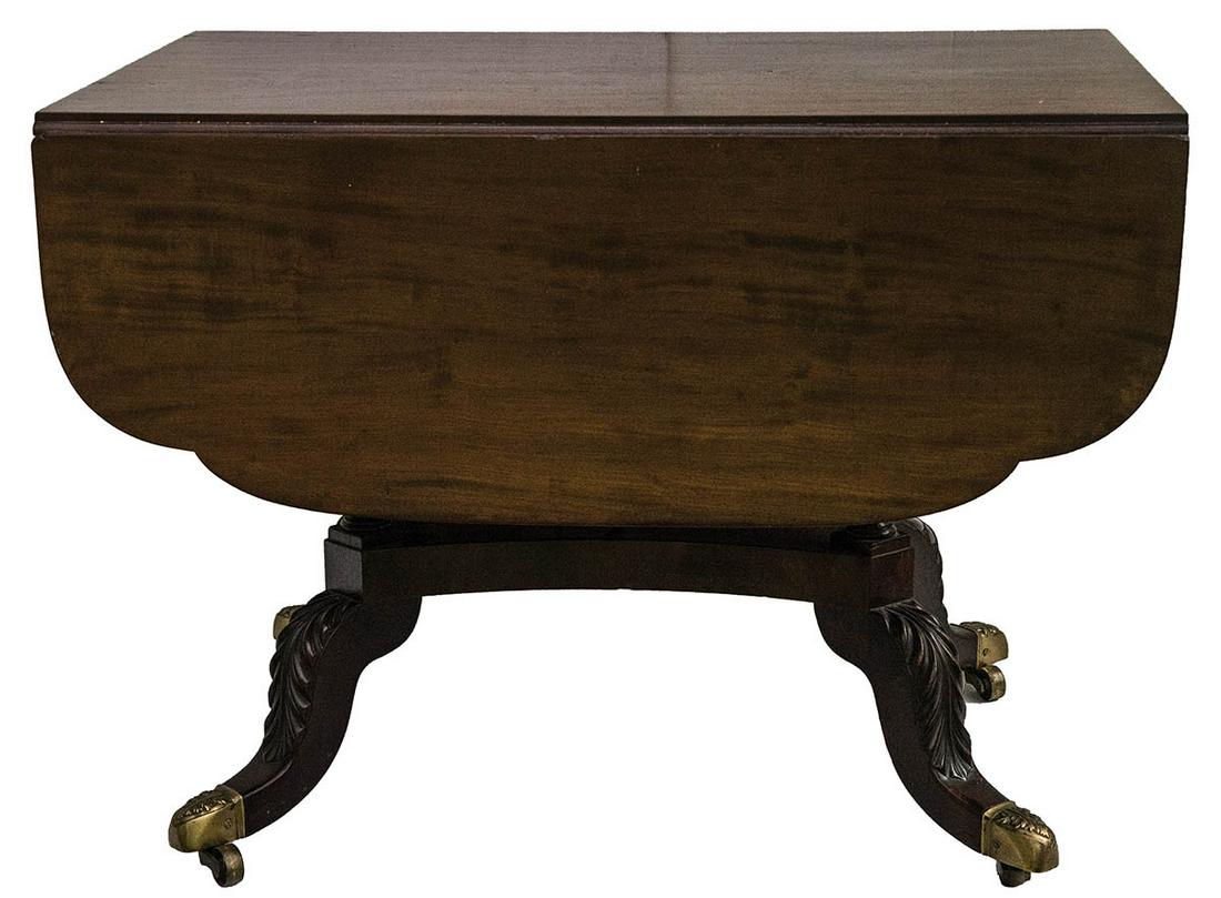 DROP LEAF TABLEEarly 19th c. School of Duncan Phyfe: DROP LEAF TABLEEarly 19th c. School of Duncan Phyfe mahogany drop leaf table, with dovetailed drawer, four finely turned and acanthus carved legs, on pedestal legs each terminating in cast brass feet,