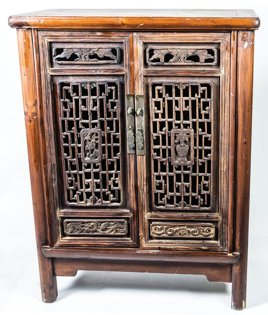 SMALL CHINESE STORAGE CUPBOARDIntricately carved panel: SMALL CHINESE STORAGE CUPBOARDIntricately carved panel doors with inset floral panels, panel sides with rectangular carved panels above, all on rounded feet, 40 1/2" h, 29" w, 16 1/2" d.