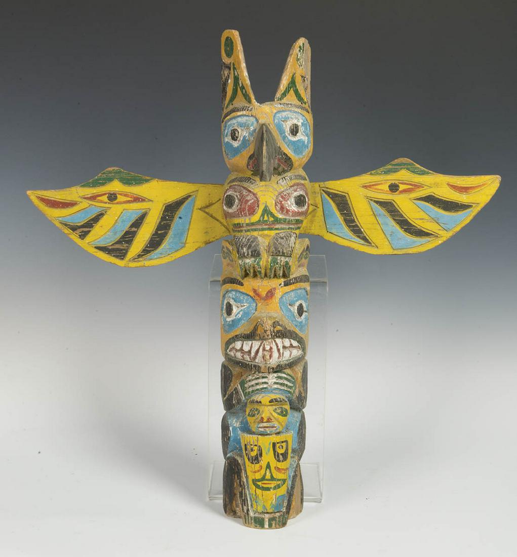 NORTHWEST COAST TOTEMMid 20th c. house totem, Northwest: NORTHWEST COAST TOTEMMid 20th c. house totem, Northwest Coast, raven, bear, wolf and human, carved wings, yellow, blue, black and white, some minor weathering, carver - Charles Moore, 24" h.
