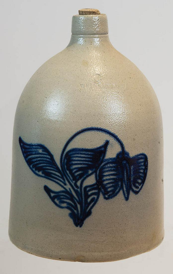 19TH C. STONEWARE JUGThree-gallon jug, "White's Utica,: 19TH C. STONEWARE JUGThree-gallon jug, "White's Utica, NY", large dark blue variegated flower and leaves, small chip at base in front, 17" h, 10" dia (at base).