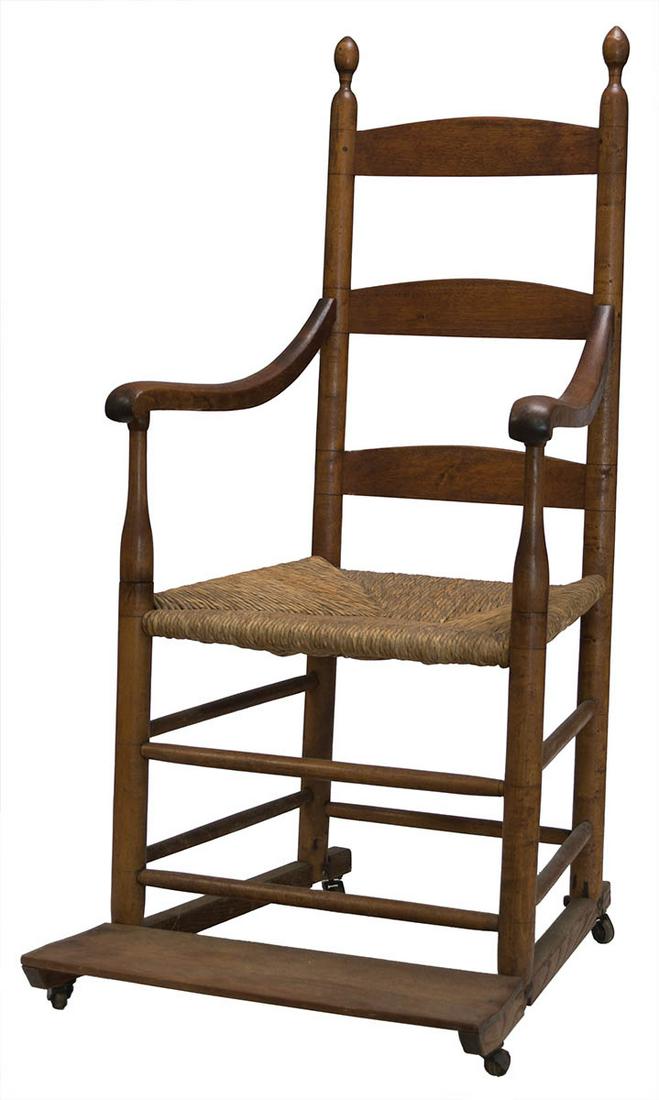 RARE INVALID'S ARMCHAIRMaple, early varnish finish with patina, three slat back, curved arms, rush: RARE INVALID'S ARMCHAIRMaple, early varnish finish with patina, three slat back, curved arms, rush seat, fitted with a footrest and extra support bar bolted underneath, with casters, New Lebanon, NY, 