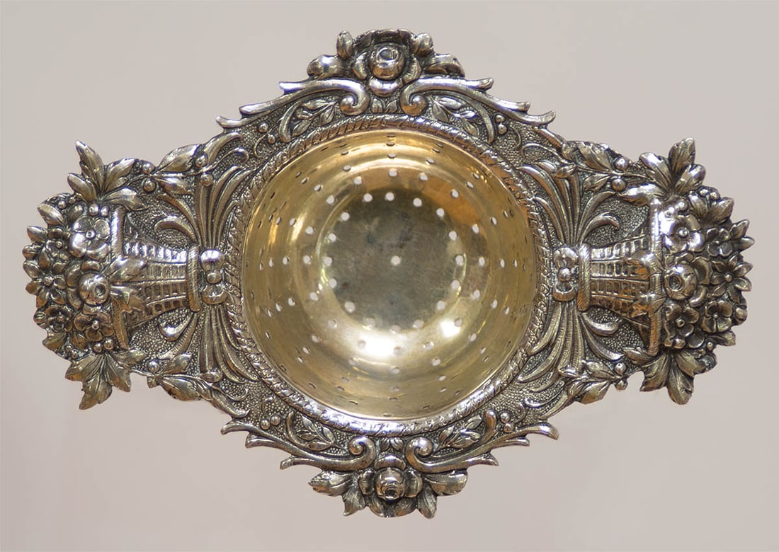 COIN SILVER TEA STRAINER Exceptional strainer with basket of flower handles, entire surface: COIN SILVER TEA STRAINER Exceptional strainer with basket of flower handles, entire surface decorated with roses, leaves, vines and lightly gilded bowl, hallmarked with a crescent moon and crown, mark