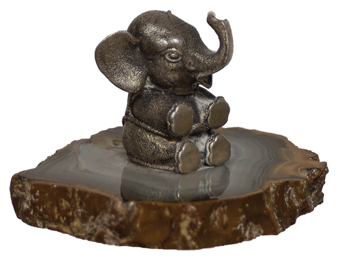 SEATED STERLING BABY ELEPHANT Sterling silver baby elephant, seated on a polished petrified wooden (1 of 2)