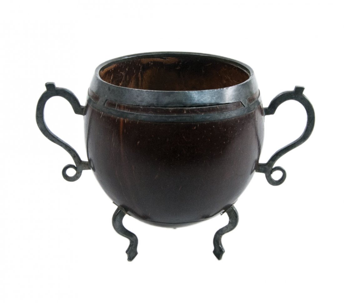 Carved coconut bowl, pewter handles: 18TH C. CARVED COCONUT BOWL Footed and handled, appointed with a split pewter rim, finely scrolled pewter openwork handles, curved leg with spritely shaped feet, 4 1/4" h, 3 3/4" dia, (ex. Brian Culli