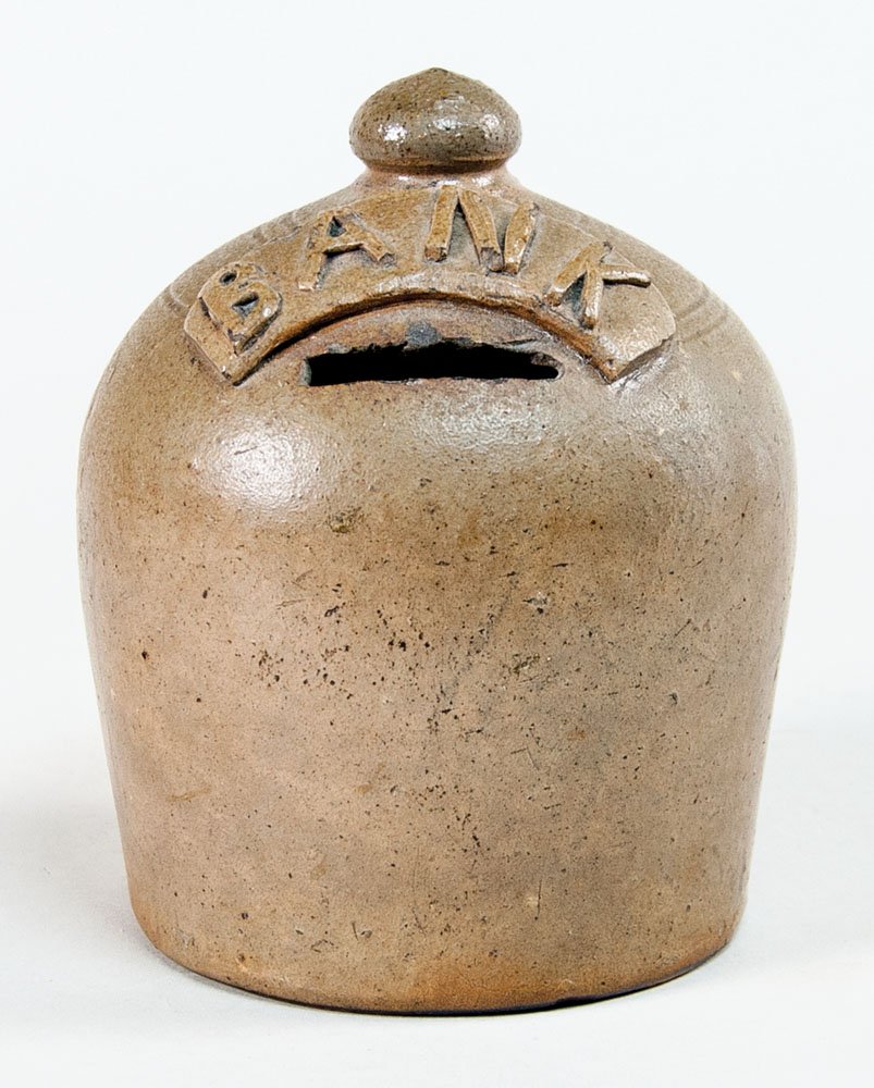 Stoneware bank: STONEWARE BANK Button top and applied banner with "BANK" on top, 1 3/4" slot for coins, in excellent condition, 5 1/4" h, 5" dia, (ex. Fertig collection).