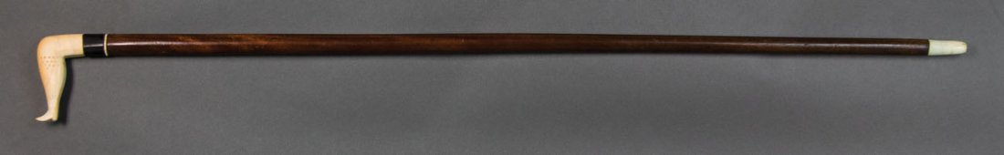 Sailor carved cane, L-shaped handle, 34" l: 19TH C. SAILOR CARVED CANE Whale's tooth "L" shaped handle, in the shape of a ladies leg, with punched decoration at calf and ankle, black baleen cuff and a whalebone ring above a tapered mahogany sha