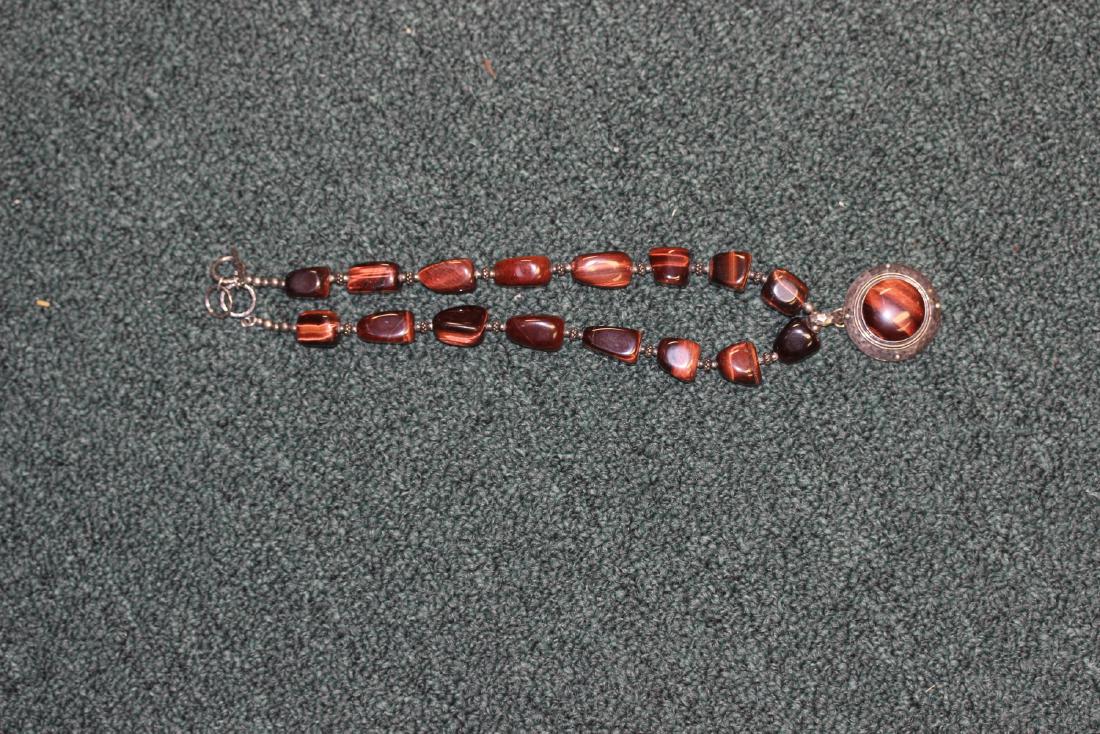 A Tiger Eye and Sterling Necklace: a choker with pendant - 11" long when clapsed - looks to be a well done piece - marked 925