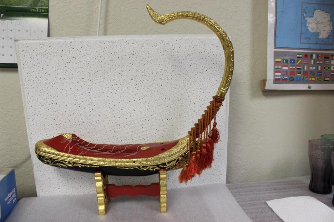 An Oriental Wood Music Instrument: in a boat form with stand - please note: handle restored - 21 1/2" tall with stand
