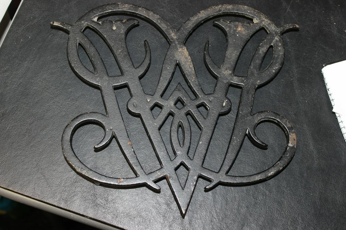 A Black Cast Iron Williamsburg Queen Ann Cypher Trivet: approximately 10 1/4" across