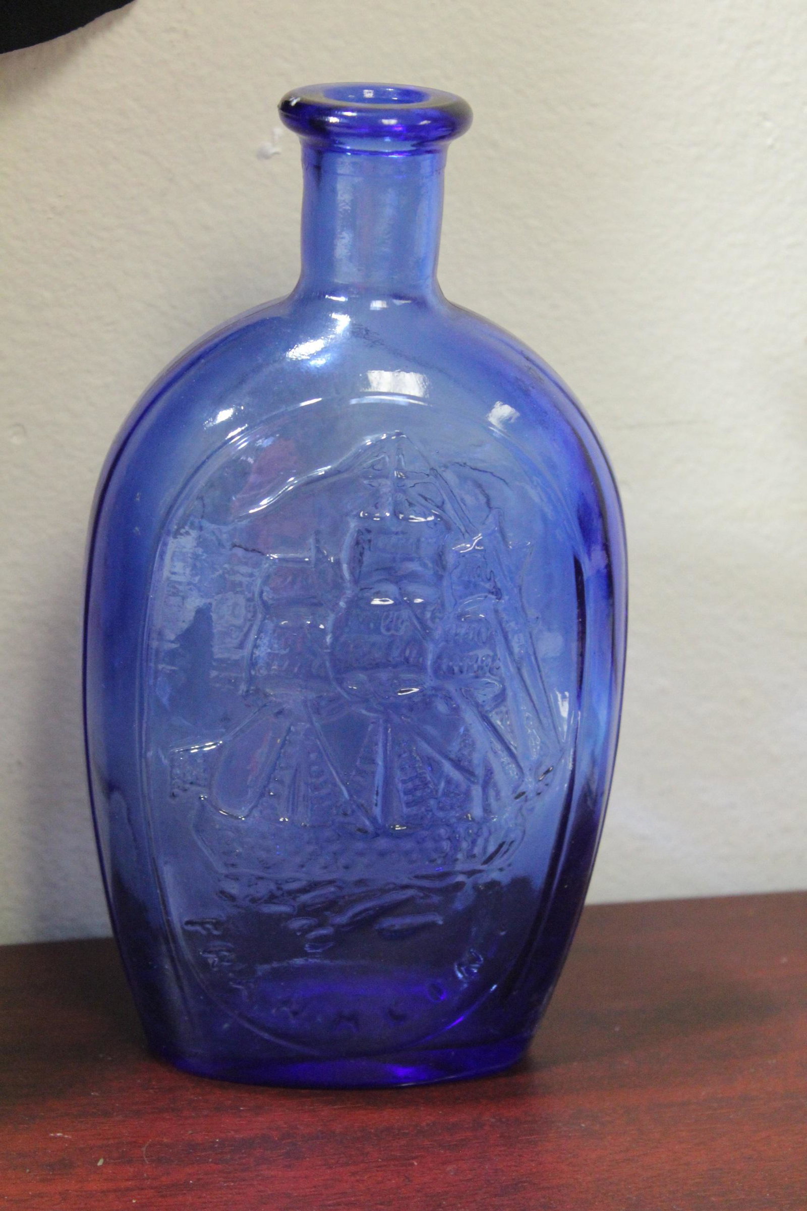 A Cobalt Blue Glass Bottle: Schooner/Eagle with shield decoration - 8 7/8" tall
