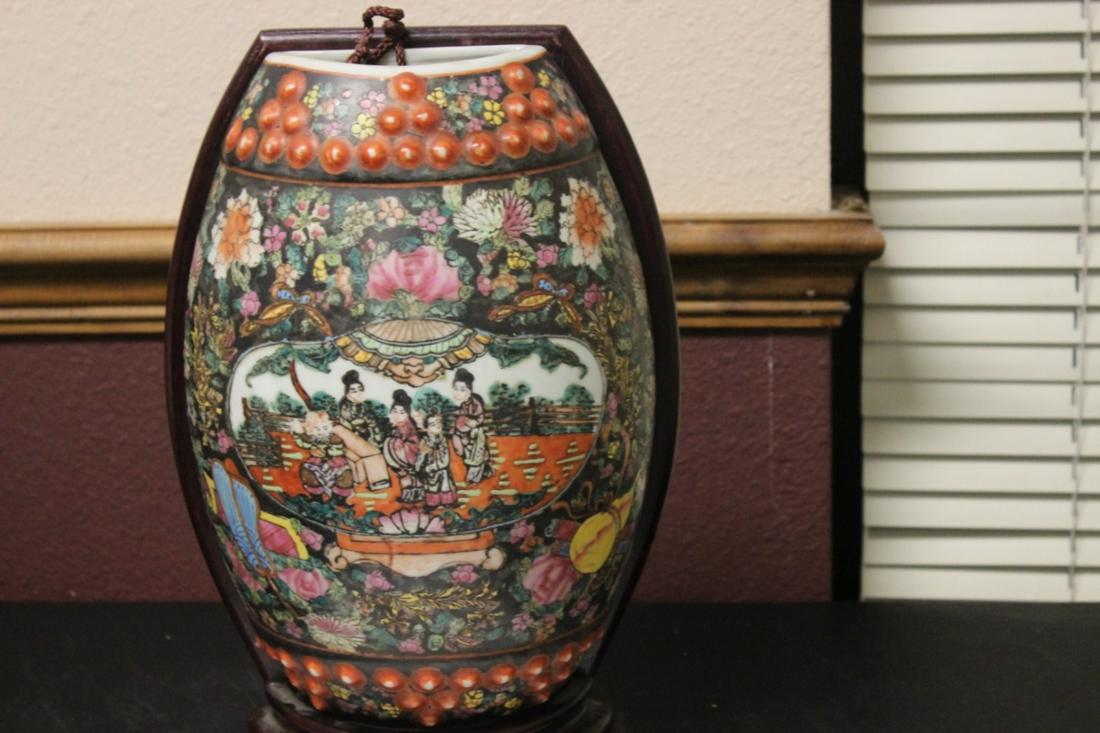 An Oriental Wall Pocket Vase: on a wood stand - with a written receipt - overall= 13" tall