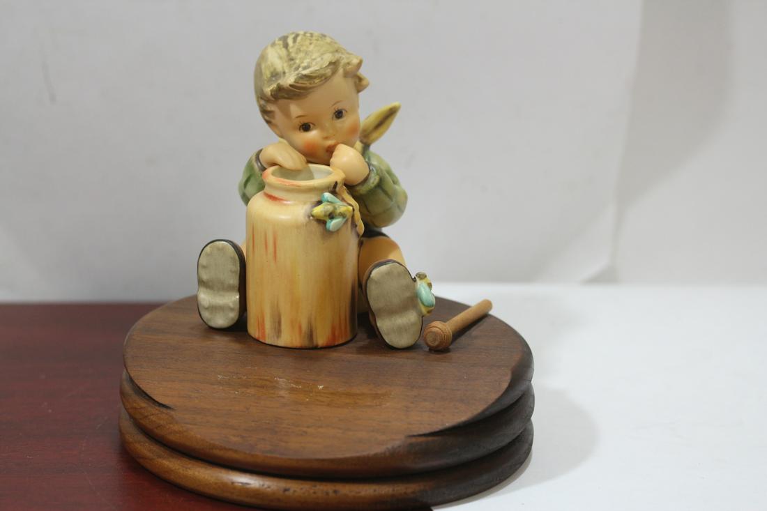 A Hummel Figurine: with wooden stand - please note: metal plate on the stand is missing - figurine= 4" tall