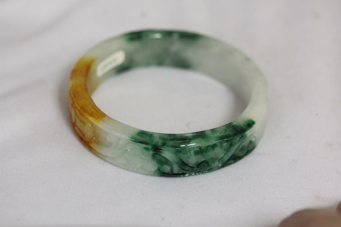 A Carved Jadeite Bangle Bracelet: tricolor - 2 1/4" inside diameter