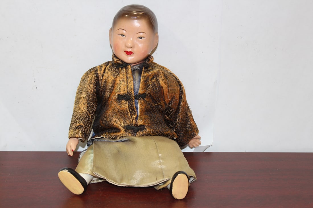 A Vintage Lacquer Doll: made in Hong Kong - with original silk clothing - please note: cannot stand by itself - cloth is worn - 10 3/4" tall