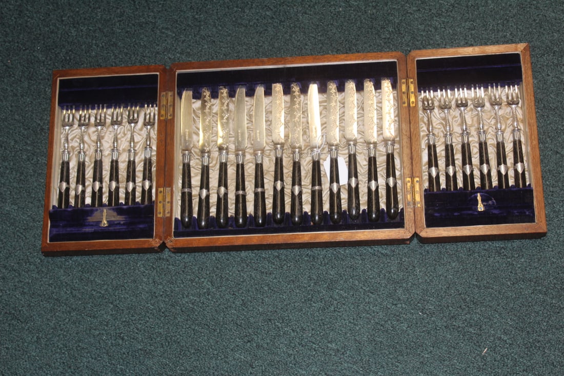 Set of 24 Utensils: inside a wooden folding box - please note: no key - handles appeared to be organic material (not wood) most likely stained bone - beautiful set - box= 12 1/4" across
