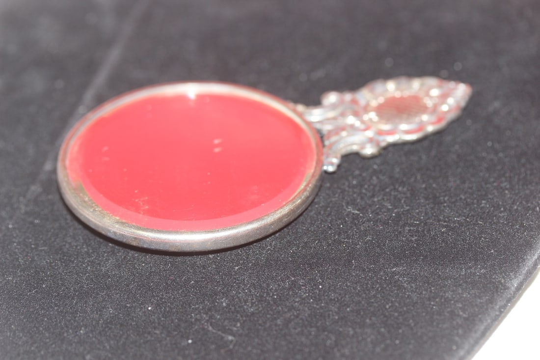 A Reposse mirror: Marked - possibly sterling - 4 1/2" long