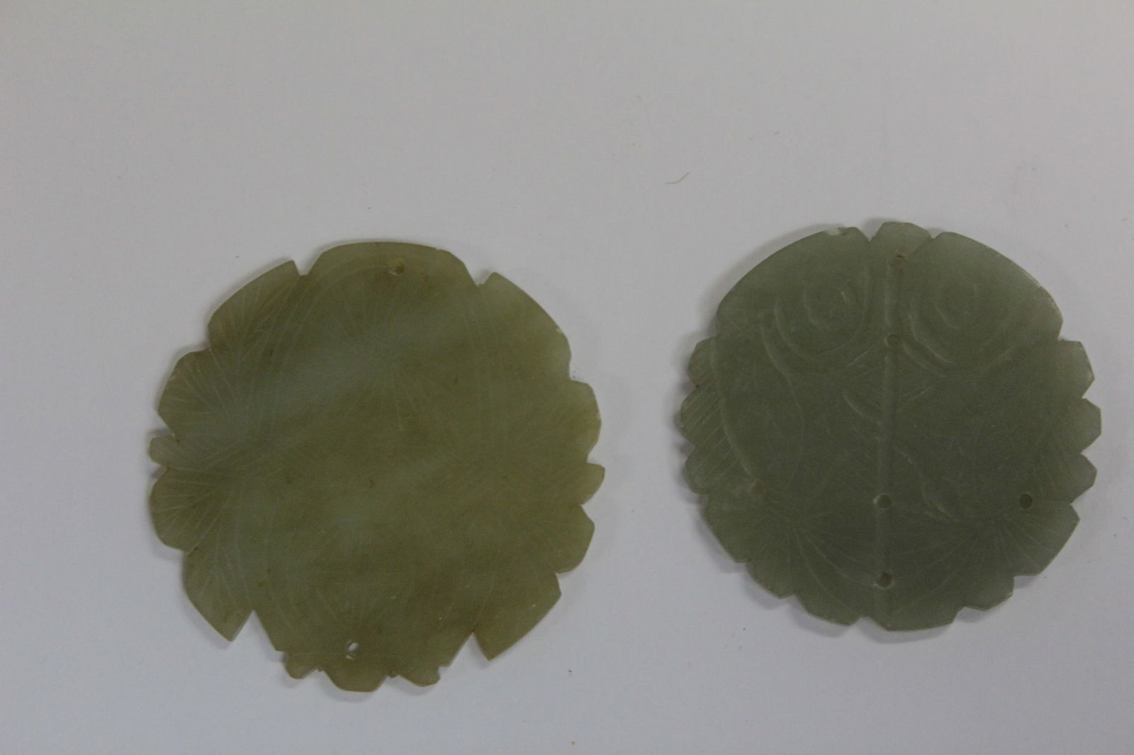 Two Carved Jade Discs: 2 1/8" and 2 1/4" in diameter respectively.