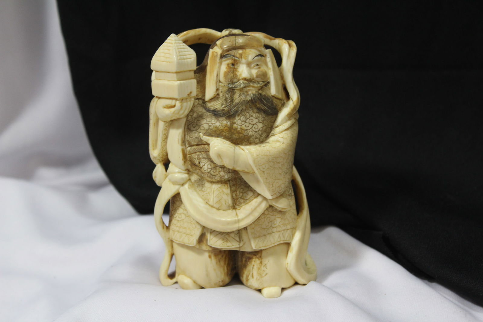A Carved Bone Oriental Warrior: looks to be old - signed - please note: crack as shown in the middle, due to age - approximately 4" tall