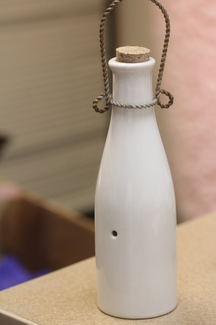 A Milk Porcelain Bottle Bell: with clasp - overall= 9" tall