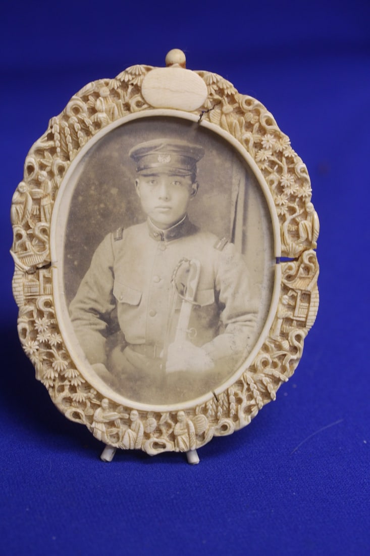A Carved Chinese Export Bone Picture Frame: with a picture of a soldier - most likely 19th century - please note: crack throughout as shown - overall= 5 1/8" in diameter - inside diameter= 3 1/4" - rare