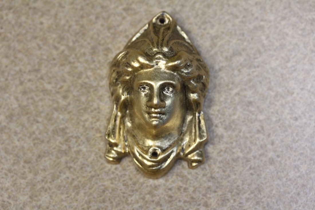 A Metal Head of a Lady: some sort of a mounting - 2 1/4" across