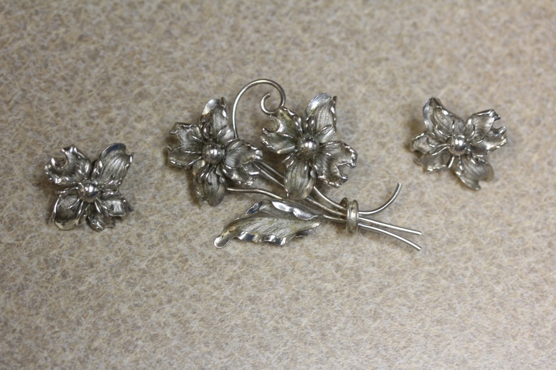 A Sterling Suite: to include a pair of earrings and a brooch - signed Bond Boyd - well carved