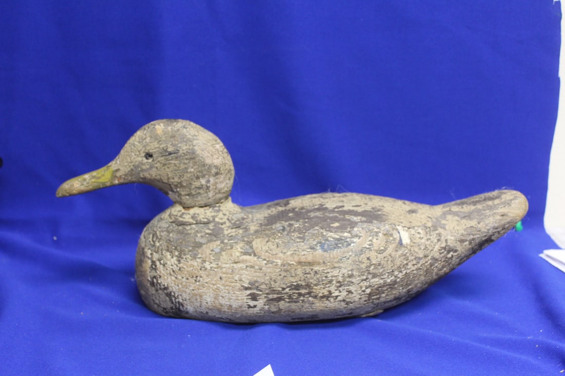 An Antique Wooden Duck Decoy: Traces of paint still visible - please note: one glass eye is missing - 15 3/8" across