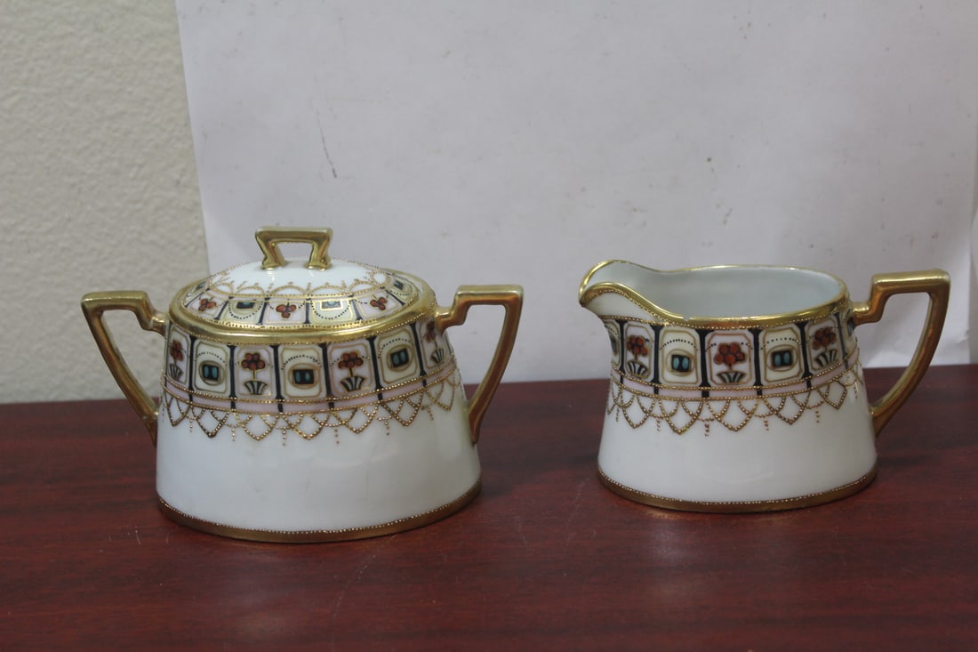 An Antique Nippon Creamer and Sugar Container: please note: tiny chip on the creamer as shown, and handle is repaired on the sugar container - longer one is 5 1/2" in diameter