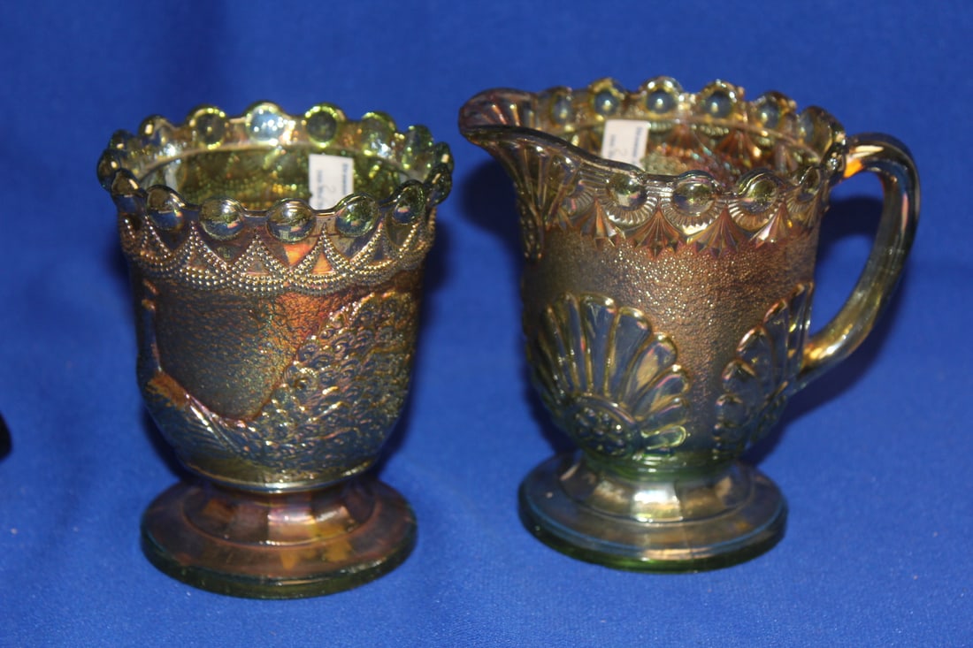 A Carnival Glass Creamer and Sugar Container: rare peacock pattern on the container - sugar= 4 1/4" tall