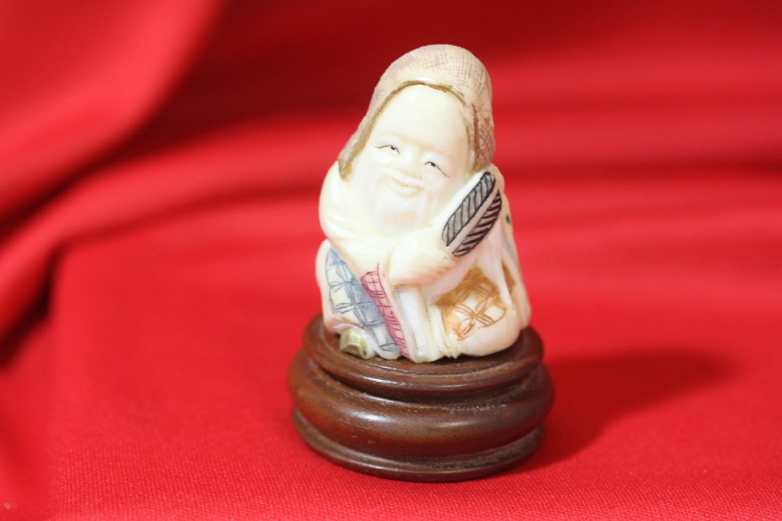 A Japanese Carved Netsuke: carved bone - on stand - possibly an okimono - 2 5/8" tall