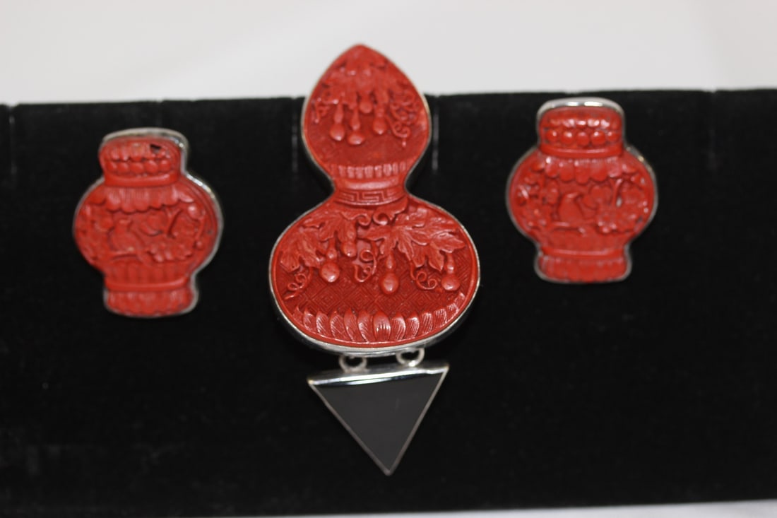 A Cinnabar and Sterling Suite: pair of earrings and a brooch/pendant combination