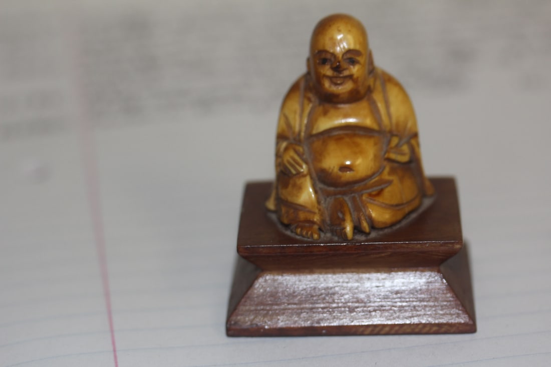 Small Carved B o n e Buddha: on wooden stand - overall= 2inches tall