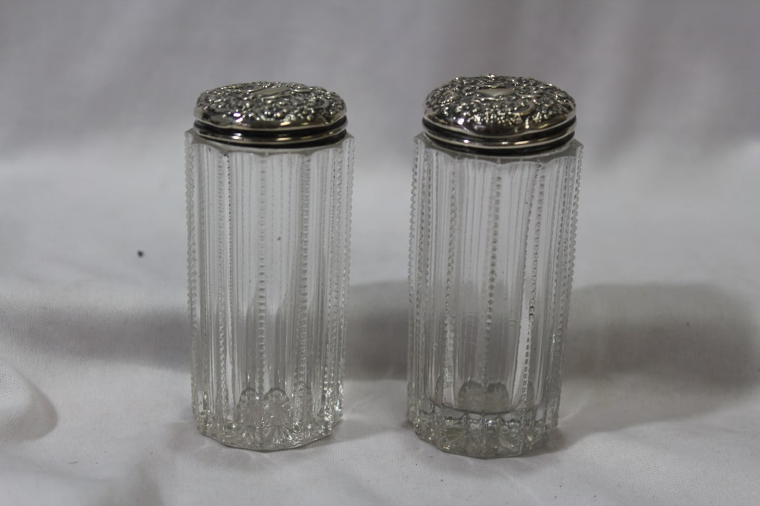 A Pair of Sterling Top Containers: Repousse Cylinder Cut Glass - one is slightly shorter than the other - the taller one is 3 1/2"