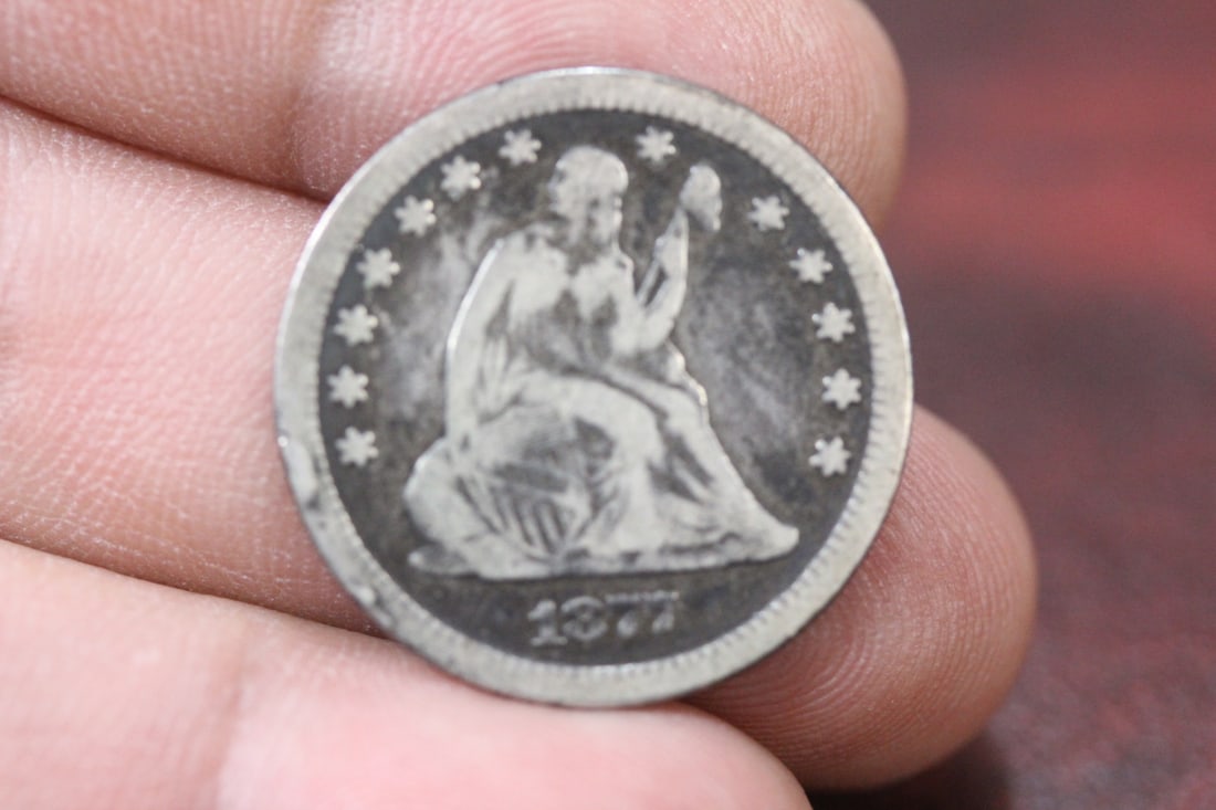 An 1877 Seated CC Quarter: as shown on photos
